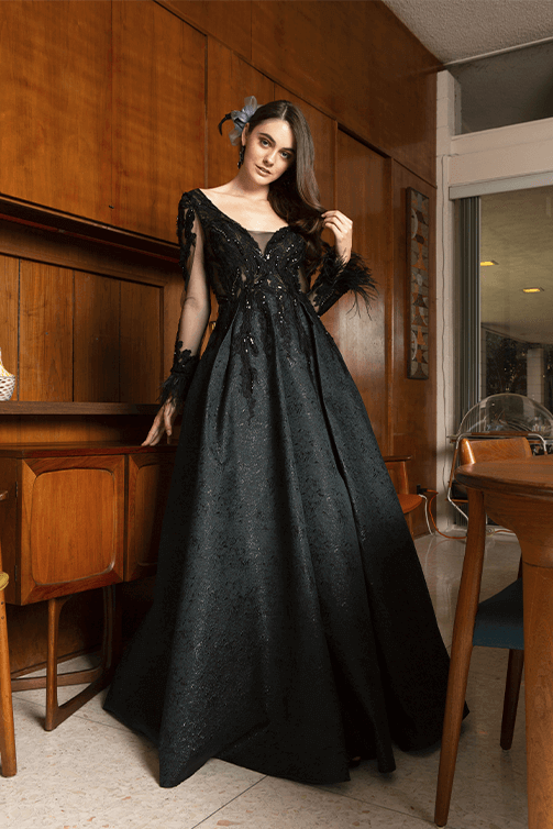 Girl in a black floor-length gala gown w/ sheer long sleeves