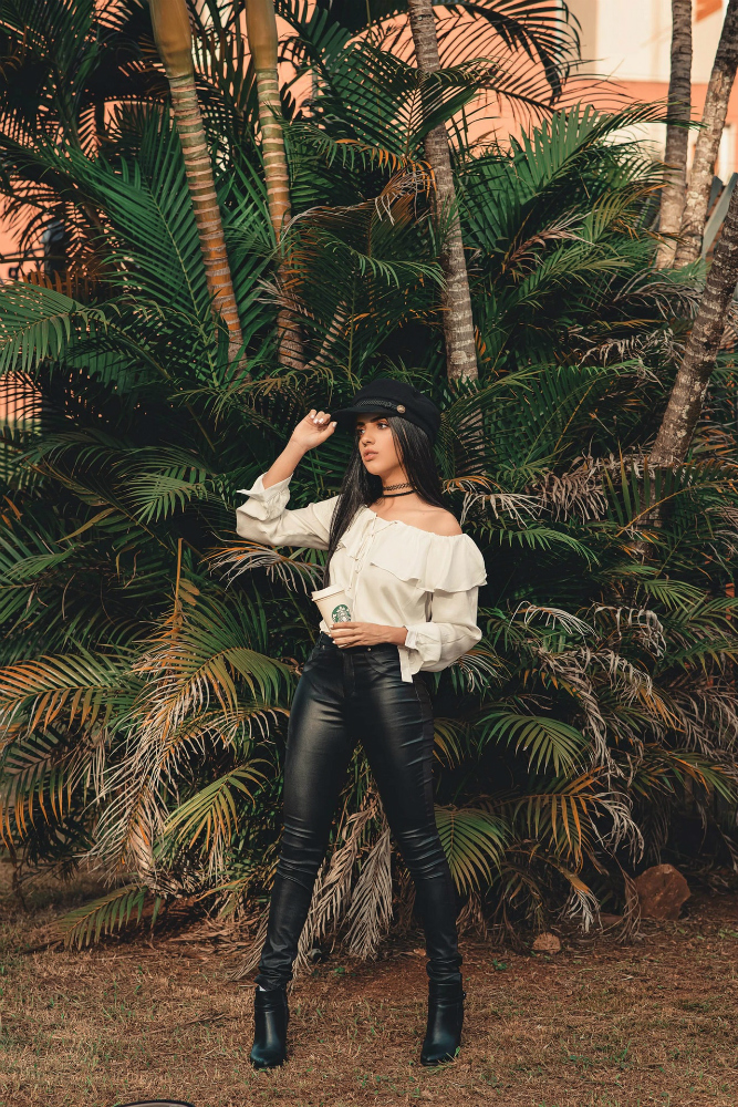 A woman wearing leather pants and a loose-fitting blouse