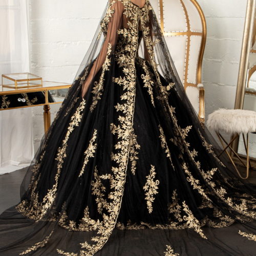 woman in a black and gold ballgown with long cape